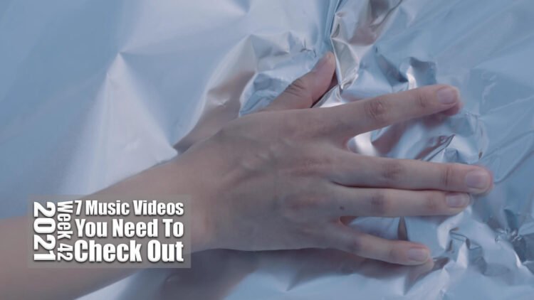 Still from the music video of Taiko Super Kicks for the track "火遊び (Hiasobi)". A hand is placed on aluminium foil.