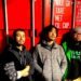 The three members of ZEROSHIKI standing against a red shipping container © ZEROSHIKI