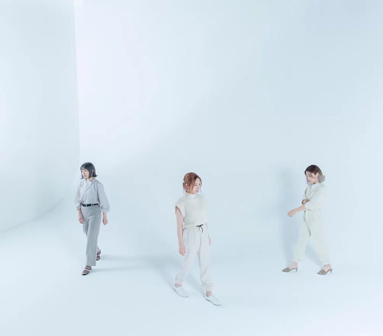 The three members of Paranoid Void, dressed in light clothing and walking around in a room that is coloured white/off-white.