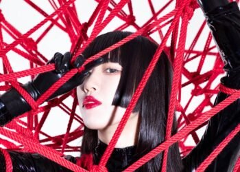 Himari Tsukishiro dressed in black-coloured lacquer clothing surrounded by red shibari rope