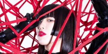 Himari Tsukishiro dressed in black-coloured lacquer clothing surrounded by red shibari rope