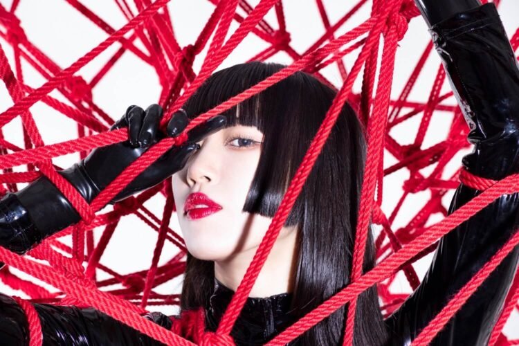 Himari Tsukishiro dressed in black-coloured lacquer clothing surrounded by red shibari rope