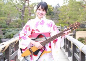 MION in a yukata holds her signature electric guitar. © MION