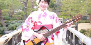 MION in a yukata holds her signature electric guitar. © MION