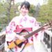 MION in a yukata holds her signature electric guitar. © MION