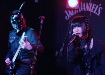PSYDOLL at The Sunflower Lounge (Birmingham). Both members are dressed in dark clothes. One of the members of PSYDOLL is wearing a leather mask with seemingly bunny ears and plays the guitar, while the other member is singing. | Photography by James Grant (wonderlens)