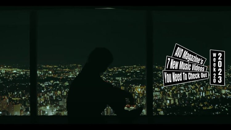 Still from the music video by the band kao for the song "New era". The still features a night view of a city and a shadow of a person that is sitting down.
