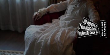 Still from RiqrhoAre00's music video for "黒いヴェール (Black veil)". A woman in a white dress is sitting on a red-coloured sofa.