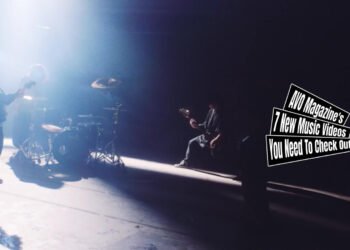 Still from the music video "NUE" by borderline case. The still shows the four band members of borderline case almost finishing playing the song while being in a deserted building, which might be a factory hall. The still is mirrored.