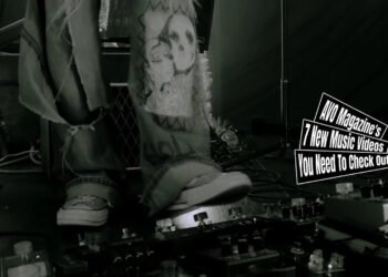 Still from The Yeahs' music video for "Anarchic Dirty Cinema". It is a starting scene where the band prepares for the song. The image is monochrome and focuses on the guitarist who prepares his pedalboard.