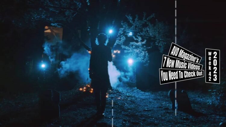 Still from the music video "ジャック・オ・ドキドキ (Jack’o’doki-doki)" by the band グラビティ (Gravity). The vocalist of Gravity is standing in the dark on a location that looks like a small graveyard with a few gravestones and a tree. There are some lights making the silhouette of the musician quite clearly, at the same time, it creates a little creepy atmosphere.