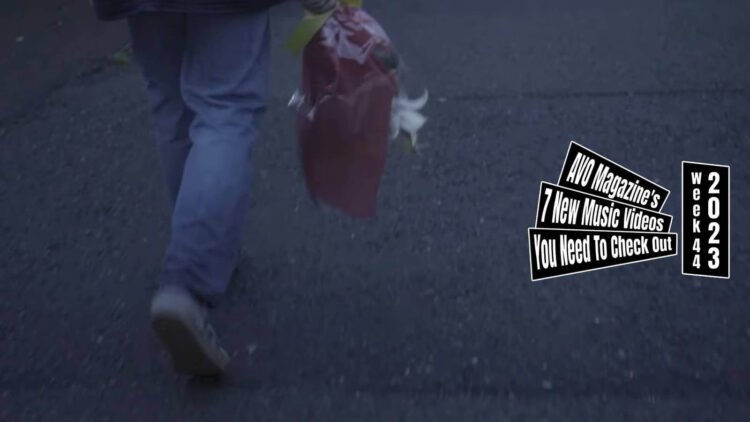Still from the music video "トーラス (Torus)" by 香山こりす (Koris Kayama). A young man walks down the street with a bunch of flowers, the still has a focus on the ground revealing jeans, shoes and part of the bunch of flowers.