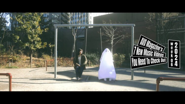 Still from the music video "ゆうれい (Yuurei)" by the band TEKKA. The still showcases a woman in black attire sitting on a swing in an outdoor playground with next to her a person with a white sheet over them, representing a ghostly figure. This creates a surreal contrast.