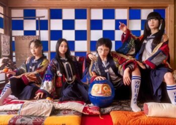 Group photo of Atarashii Gakko!, with the four members seated in a Japanese-style room, dressed in their sailor uniforms and on top of it traditional Japanese garments with a modern touch to promote their single release "Toryanse". © ASOBISYSTEM & TWIN PLANET CO,.LTD