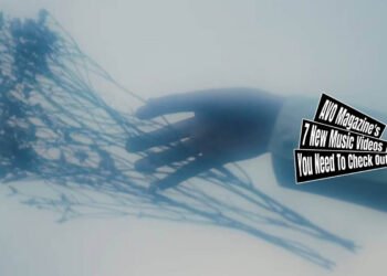 Still from Plums' music video for the song "生活 (Seikatsu)". The still shows an outstretched hand in a white sleeve against a white background with a dreamlike, hazy atmosphere. The hand is letting goew of a what seems to be a some herb branches.