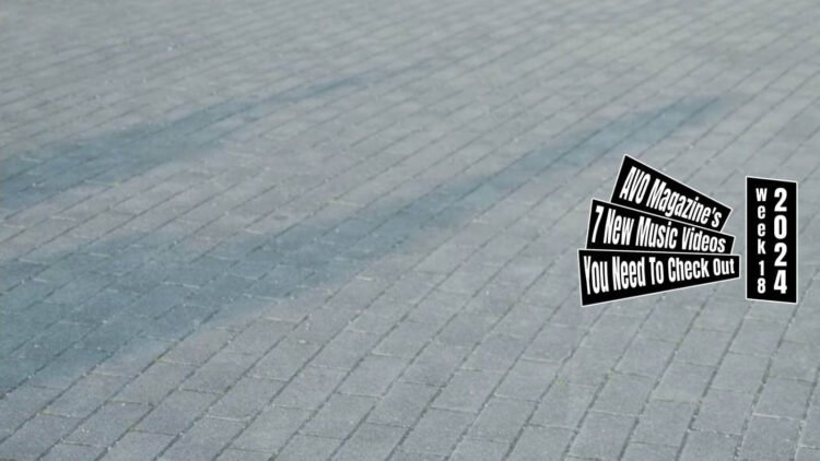 Still from Uto's music video for "旅する人へ (Tabi Suru Hito E/Stranger)". The two musicians of Uto, Hikari Kubota and Baysatoh, are dancing in the sun and the shadows of this can be seen on the pavement. Director of the music video is shoheyhey and cinematographer is JOJI.