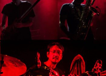 A collage of the three musicians that art part of RuinsZU in a red hue, on the top left Massimo Pupillo on bass guitar, adjacent to him on the top right, Luca T Mai playing a saxophone and on the bottom, Yoshida Tatsuya on drums.