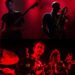 A collage of the three musicians that art part of RuinsZU in a red hue, on the top left Massimo Pupillo on bass guitar, adjacent to him on the top right, Luca T Mai playing a saxophone and on the bottom, Yoshida Tatsuya on drums.