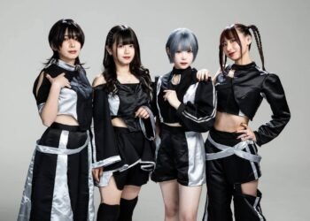 The photo features the four members of Broken By The Scream standing shoulder to shoulder against a light background. They are wearing coordinating black and silver costumes and each having a unique hairstyle.