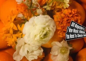 Still from Natsudaidai's music video for the song "青果店 (Seika-ten, Fruit Store)" which is directed by yama. The still showcases an artistic and vibrant arrangement of several oranges (most probably the Natsudaidai) with a bouquet of white and orange flowers placed on top. The music video is directed by yama, with director of photography Sota Ouchi, assistant director lilgonzaemom, and art director sHu.