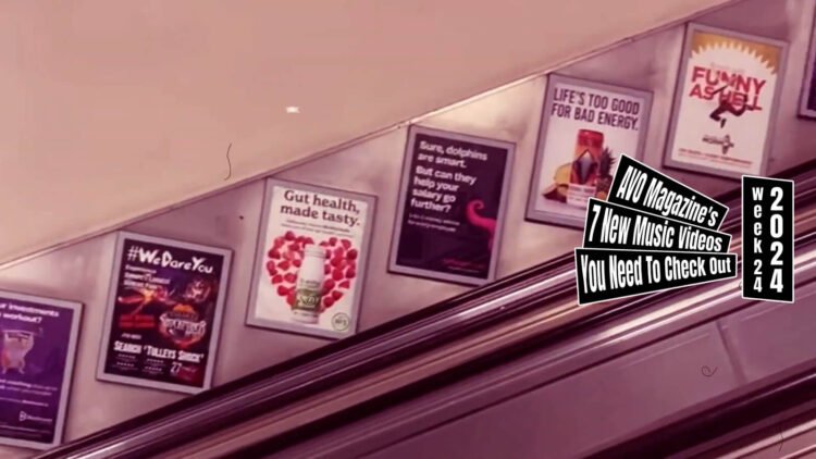 Still from the music video "FRIDAY" by the trio QUINCAMPOIX. The still captures a scene inside a subway, featuring a flight of escalator stairs. Along these escalator stairs, a series of posters with various messages and advertisements are mounted on the wall.