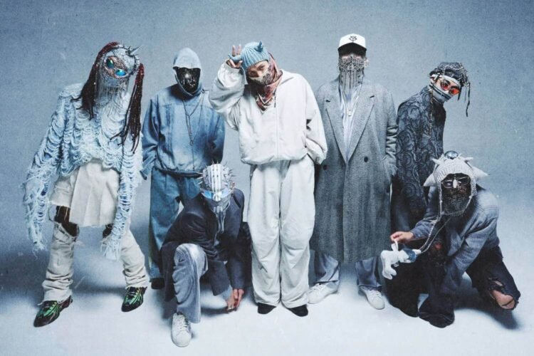 The photo features a group of seven individuals that are part of MILLENNIUM PARADE. The members are all alight in various poses and outfits, in the centre is Daiki Tsuneta, he is the only one where his eyes is not obscured.