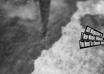 A still of the music video "輪 (Zoetrope)" by ゆうさり (Yuusari) - directed by Shiro Ose. The still is monochrome and shows the ground with puddles of water and a reflection of what appears to be a tower or a long pole. Director Shiro Ose (@shiro_ose on Twitter/X) shared in a tweet that the music video is filmed with a toy camera.