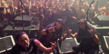 The Japanese band Abigail posing in front of an audience after a live show.