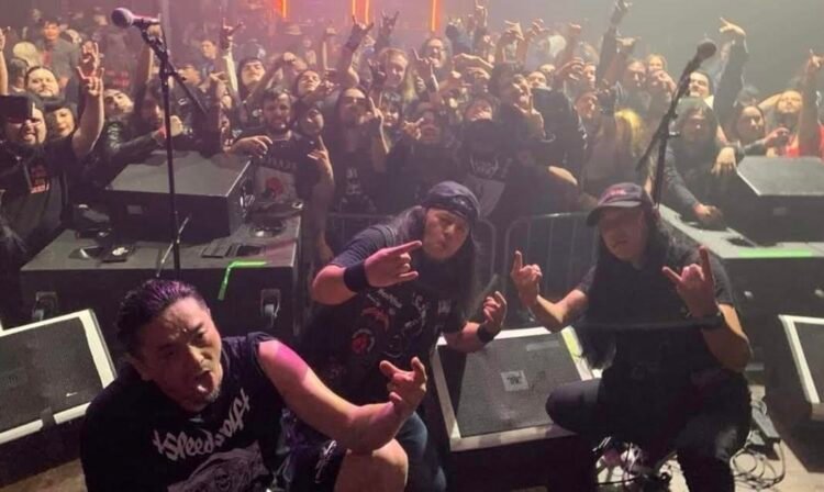 The Japanese band Abigail posing in front of an audience after a live show.
