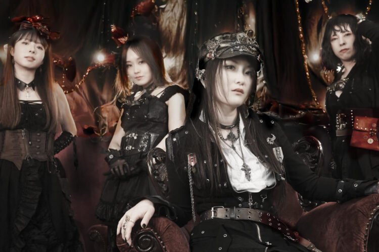 The photo shows the steampunk metal band FATE GEAR, dressed in dark gothic and steampunk inspired fashion. The bandleader, 'Captain' Mina, sits in front of the other three standing members.