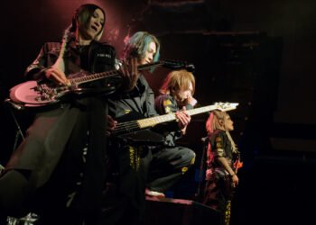 Four members of NIGHTMARE at the front of the stage, standing closely together during the performance in London. Photo by JJ Grant/wonderlens