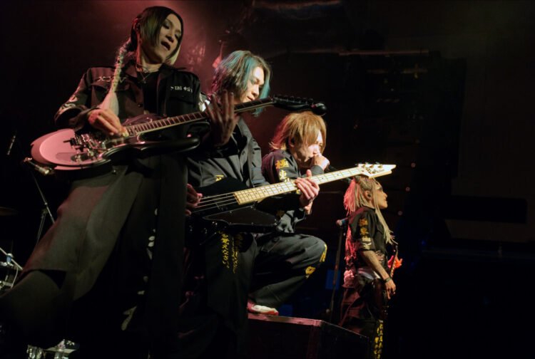 Four members of NIGHTMARE at the front of the stage, standing closely together during the performance in London. Photo by JJ Grant/wonderlens