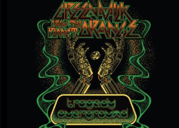 Apart from the addition of the band logo and the song title placed, the background is completely black. In the centre of the image, two robotic hands are shown and in the middle of these hands a coin with an eye on it is placed. This is surrounded by a sort of halo and green smoke.