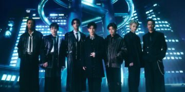 Photo of the seven members of PSYCHIC FEVER from EXILE TRIBE standing next to each other in a futuristic setting. They are dressed in dark clothing, inspired by suits, but with different elements showing their personalities, from leather jackets to extra accessories.