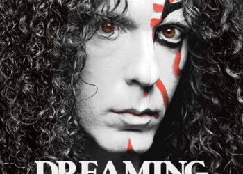 Cover art for 'Dreaming Japanese' with a monochome photo of Marty Friedman with long curly hair. Part of his face painted in kabuki theatre style, using the colours white, red and black. Cover art by Jim Villaflores