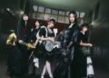 Photo shows the five members of BAND-MAID, from left to right: Misa, Akane, Miku, Saiki, and Kanami, partly dressed in maid-inspired clothing and partly dressed in black attire. Apart from the vocalist, they are all holding their instruments. © BAND-MAID