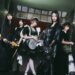Photo shows the five members of BAND-MAID, from left to right: Misa, Akane, Miku, Saiki, and Kanami, partly dressed in maid-inspired clothing and partly dressed in black attire. Apart from the vocalist, they are all holding their instruments. © BAND-MAID