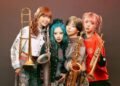 Band photo of the four women of brass band MOS. They all have colourful hairstyles and are dressed differently, showing off their individuality. Photography by Youhei Nobe (@/youhei_nobe on Instagram)