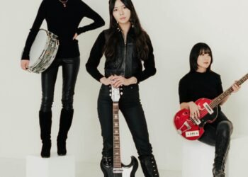 A group photo of The Highmarts as of 2025, used for the promotion of several performances in 2025, with the members Suzu, Minori and Shiori. They are all dressed in a black (leather) attire, while the background is white. Some members are posing on white blocks, all holding their instruments. © The Highmarts