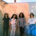 The photo features the four men of krautrock band Minami Deutsch. They are standing next to each other against a painted wall somewhere outside (in the United States), dressed casually. Most of them are wearing sunglasses as it is sunny weather. Photo by Tyler Loring @/everwavecreative on Instagram