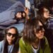 Band photo of the four members of DYGL posing in front of a camera, but most are not looking into the lens and two of them are even looking away. The musicians are dressed casually and all wearing sun glasses. They are posing in front of a gate and a train is visible in the background. Photography: Earl Standerford