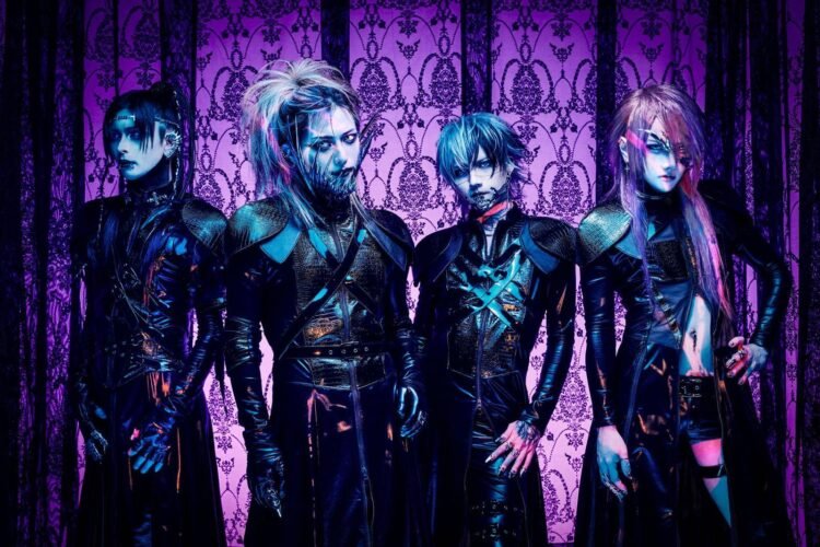 The photo features the four members of JILUKA, dressed in distinct dark, gothic attire with silver face jewelry (such as a chin, eye or ear piece) posing against a purple gothic-themed screen.