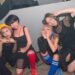 The four members of cheer punk band Ni-hao!!!! posing together before or after a show. They are all dressed in black clothing and wear coloured socks. © Photo by Yukiko Ono