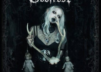 EP artwork cover for Godfrost's EP release 'Hanging Doll'. It is a monochrome photo of a woman with long hair, dressed in a black dress with a gothic theme. It has eerie elements with dark makeup and lenses that makes her eyes white. She is holding horns whanging dolls attached to them.