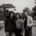 Black-and-white photo of the three members of Tō Yō facing the camera. They are standing together in a park with the background filled with trees. Photo by Takaumi Minagawa